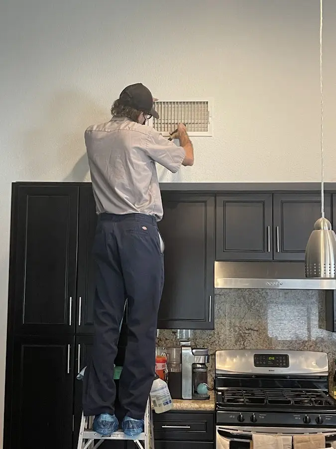 Technician inspecting an air vent during HVAC service in Roselle